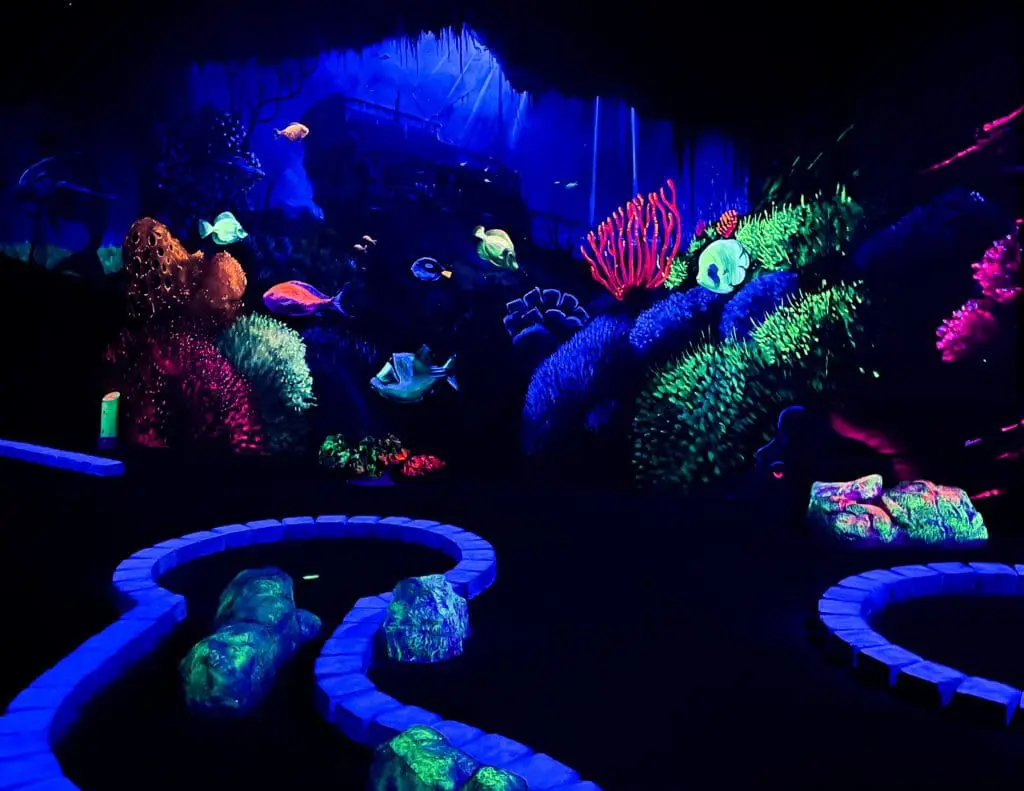 Glow in the dark minigolf baan met vissen op de achtergrond