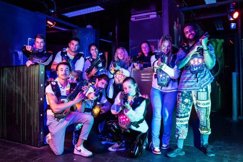 Groep van mannen en vrouwen die poseert in de lasergame arena van Aloha