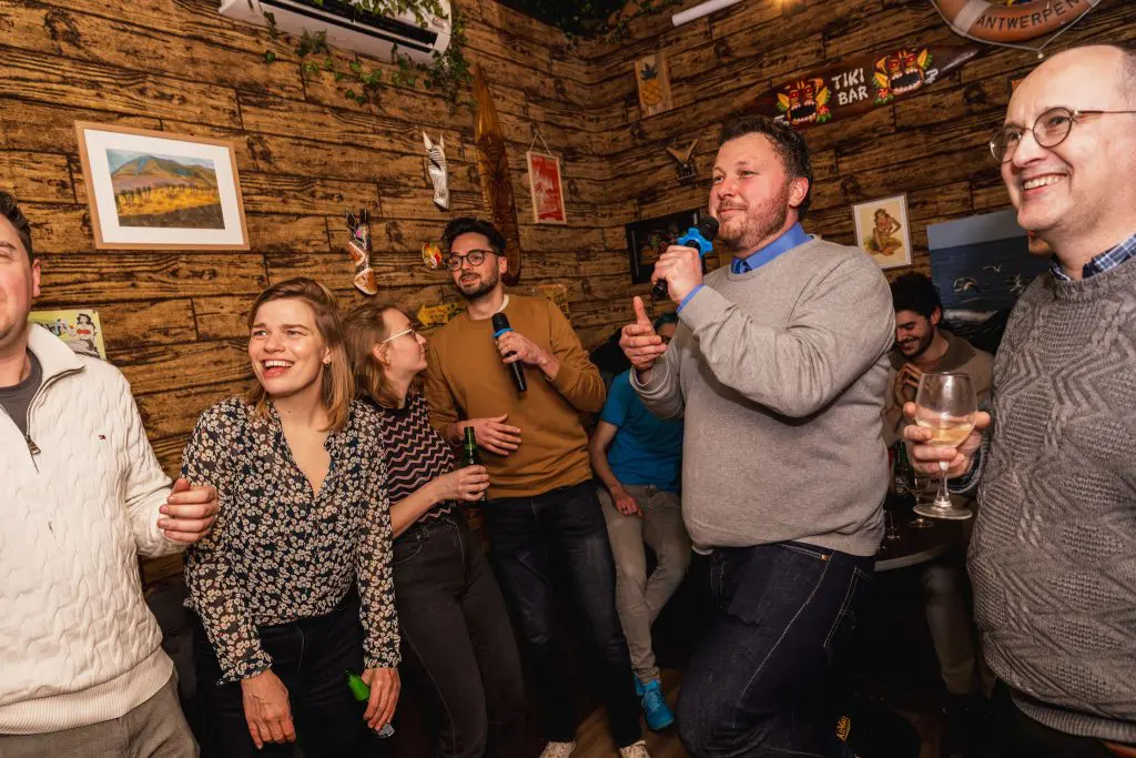 Groep mannen en vrouwen zingt karaoke
