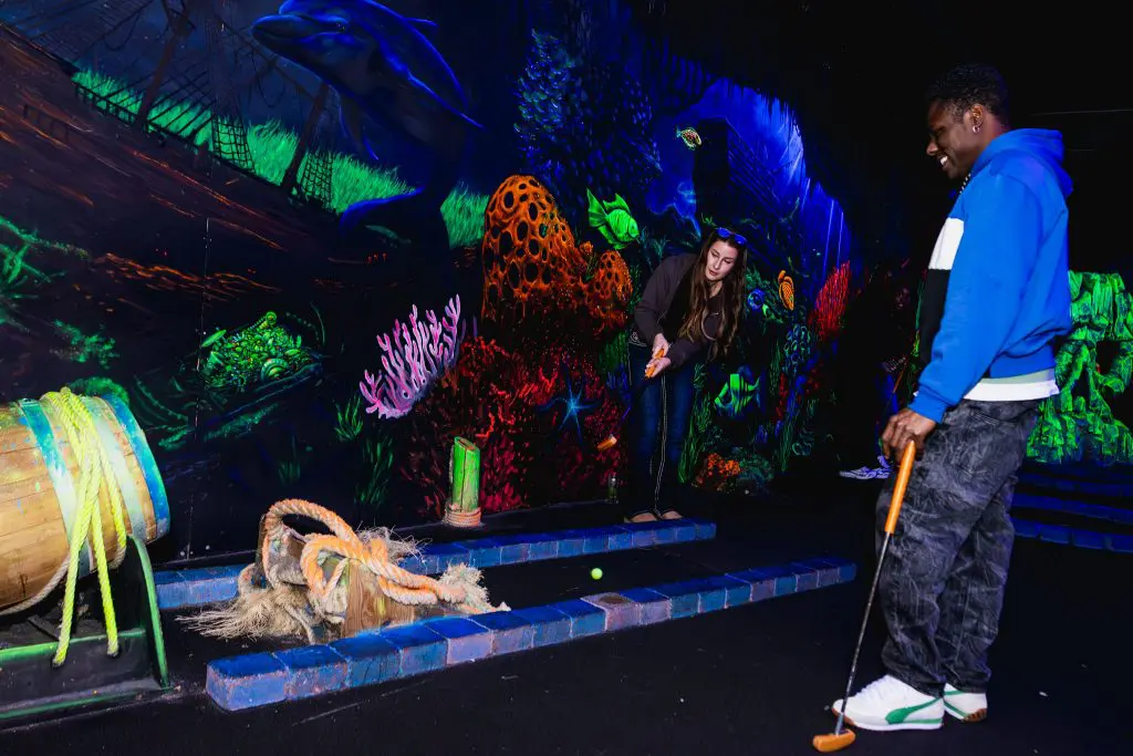 jongen en meisje spelen minigolf