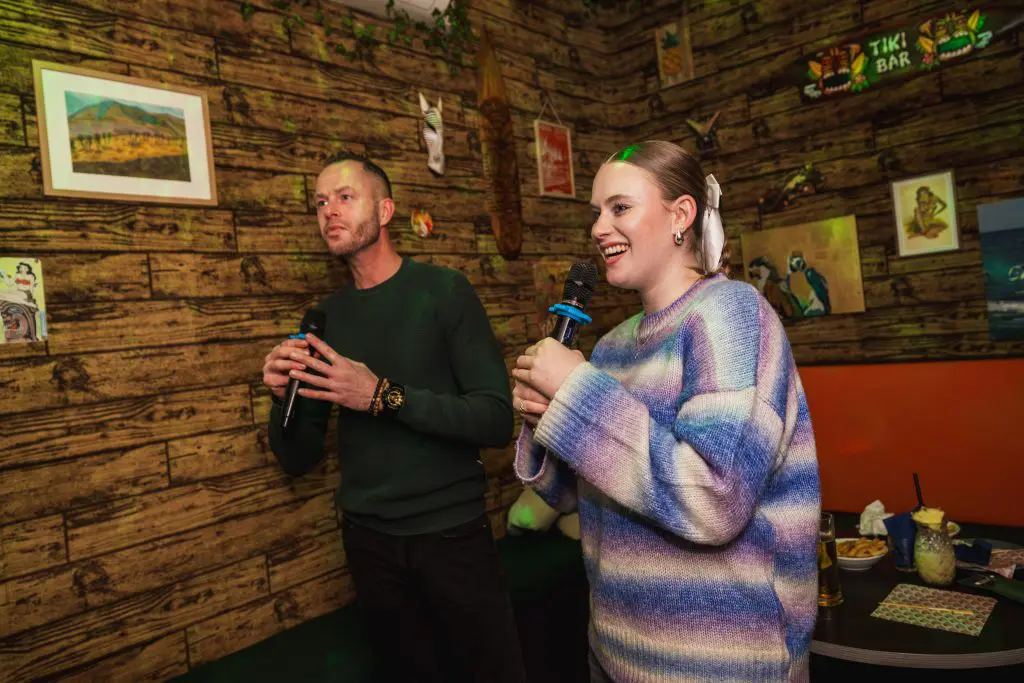 Een jongen en een meisje zingen karaoke