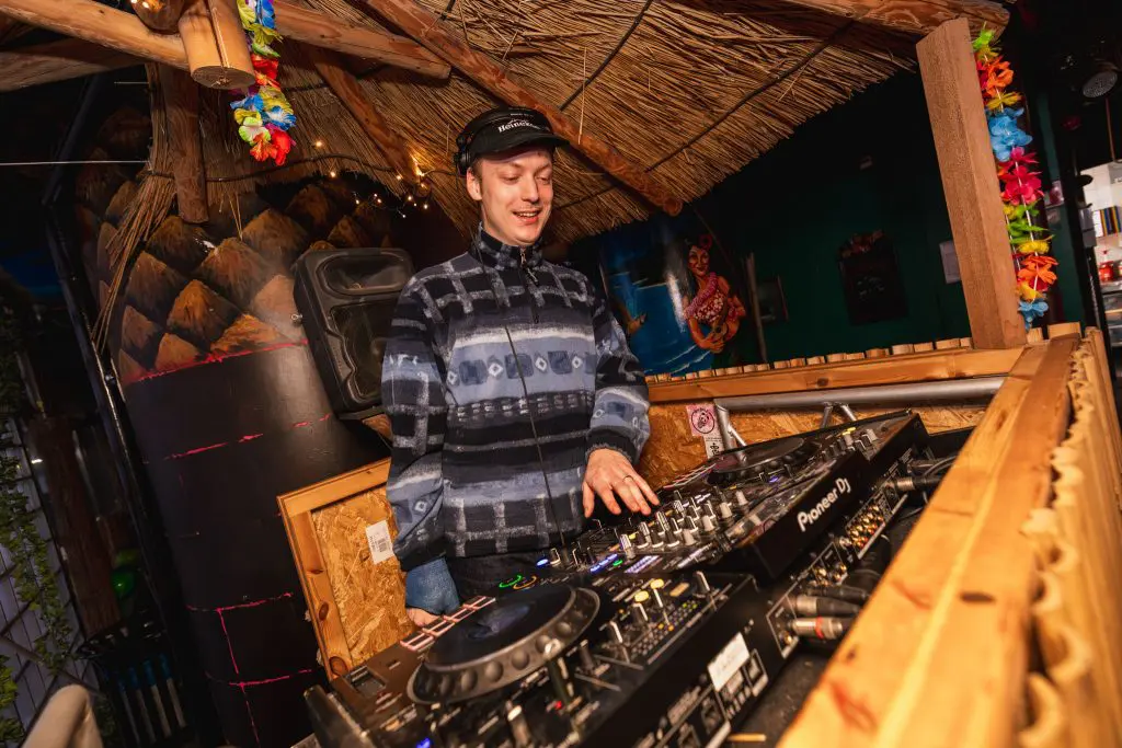 DJ draait muziek in een tropisch aangeklede setting