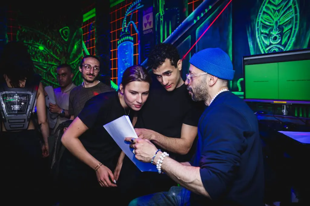 Groepje mannen en vrouwen in de lasergame area die iets lezen op een blaadje