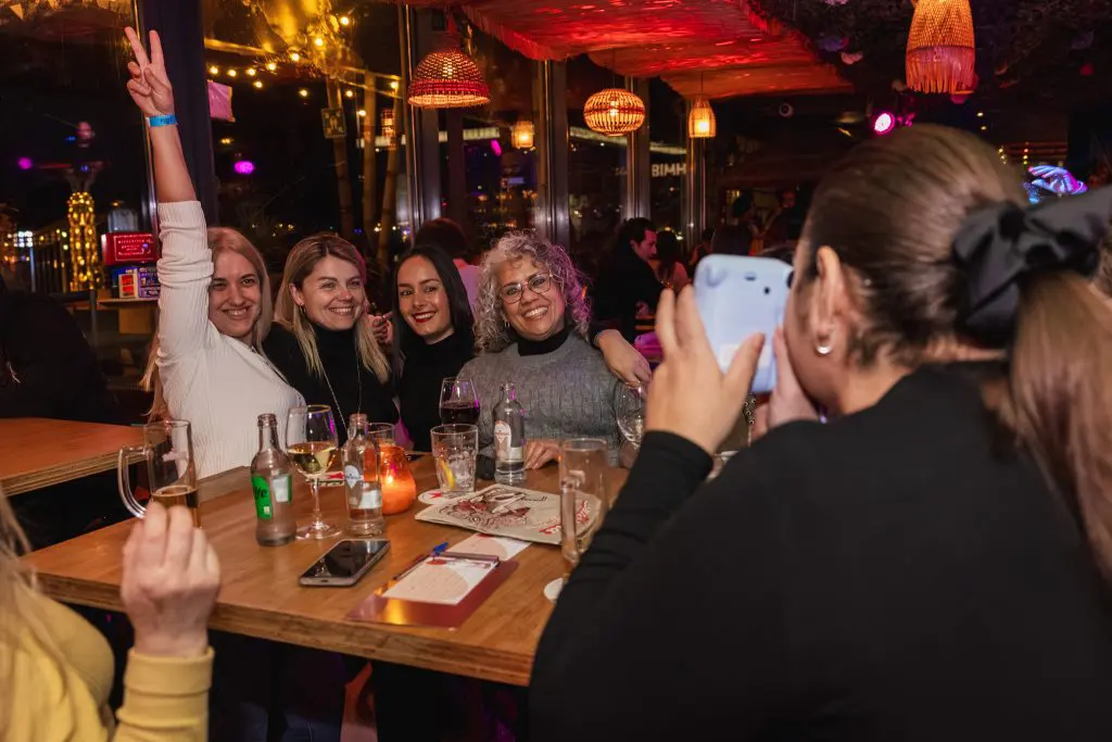 Groepje vrouwen die op de foto gaan met een polaroid camera