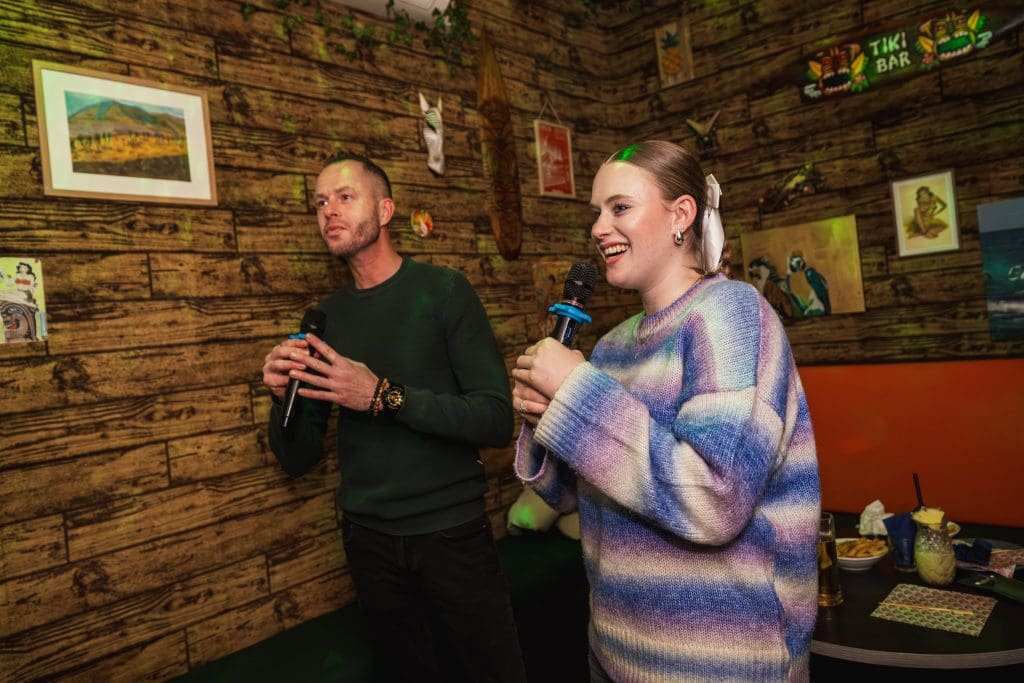 Een jongen en een meisje zingen karaoke
