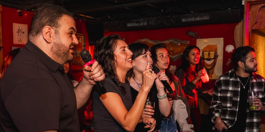 Groep jongens en meisjes die karaoke aan het zingen zijn